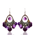 Detalle de pendientes bohemios con marco de bronce y borlas de conchas púrpuras - Morado