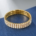 Close-up of three-row gold elastic bracelet featuring sparkling white rhinestones - 3 Rows / Gold
