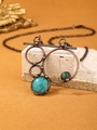 Retro bronze pendant necklace with teal green natural stones on a stone base display - Amazonite