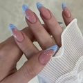 Detail view of almond press-on nails with nude base and light blue french wave tips - DS56-Nude Light Blue Wave French Almond