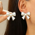 Elegante witte emaille strik oorbellen met gouden rand en kristallen op model - KC Goud Witte Strass Kunstmatige Parel Strik (1219)