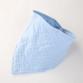 Détail d'un bavoir bébé en mousseline bleu clair avec texture douce et bouton pression - Bleu ciel