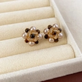 Dettaglio orecchini a fiore con perle e cristalli in un portagioie di velluto - Stile Fiore Perla / Oro con Caffè