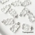 Close-up of transparent resin gummy bear charms with silver metal loops for DIY jewelry - Clear