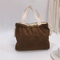 Close-up of brown corduroy fabric texture and creamy drawstring on a small handbag - Coffee