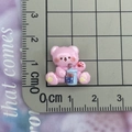 Detailed view of a pink resin bear charm holding a blue milk tea cup for DIY crafts - Pink Milk Tea Bear