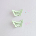Close-up of two mint green butterfly hair clips with wavy snap metal design - Matte Butterfly / Green