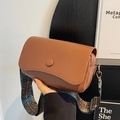 Brown lychee texture crossbody bag with a colorful ethnic patterned wide strap - Brown