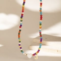 Detail of colorful beaded necklace with white heart charm and gold metal letter J pendant - Letter J
