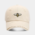 Gros plan sur la broderie d'abeille et les trous vieillis sur la casquette beige - Réglable / Beige