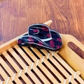 Cowboy hat shaped hair claw clip in black with red rose patterns on a wooden tray - Cowboy Hat Style Claw / Black Rose Hat