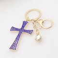 Detailed view of golden cross keychain featuring blue rhinestones and lobster clasp - Blue