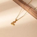 Close-up of golden stainless steel Christmas gingerbread man pendant necklace - Santa Letter L