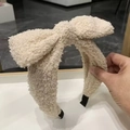 Beige faux shearling wide headband featuring a large plush bow and soft texture - White