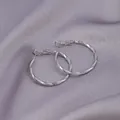 Silver hoop earrings with textured diamond-cut finish on purple velvet background - E-046---platinum 30mm