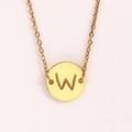 Gros plan détaillé d'un collier doré avec un pendentif pièce ajouré de la lettre W ciselée - Lettre W