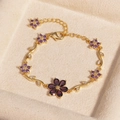 Luxuriöses Goldarmband mit lila Zirkonia-Blumen, präsentiert in einer Geschenkbox - Blume Lila Zirkon Gold