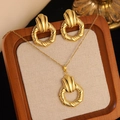 Detailed shot of golden necklace and stud earrings set with spiral textures on a tray - Gold Spiral Pattern Vintage Jewelry Set