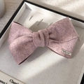 Dettaglio di un fermaglio per capelli in feltro rosa fatto a mano con placca dorata - Rosa Viola