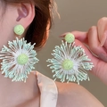 Primo piano di una modella che indossa orecchini a fiore in tulle verde menta fresco - Stile Esagerato di Fiori Intrecciati Radiali (21#) / verde chiaro