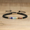Close-up of handmade woven bracelet with natural stones and adjustable black cord - No.74 Matte Black & Seven Chakra