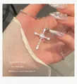 Elegant silver cross necklace with pavé cubic zirconia held in hand, chic starburst design - Silver Full Diamond Starburst Cross