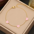 Primer plano de pulsera dorada con dijes de corazones rosa y ojo turco en cuero - Rosa