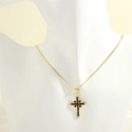 Close-up of cross pendant featuring black marquise stones and 18K gold snake chain - Gold Snake Chain / Black Zircon