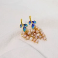 Blue enamel leaf earrings with irregular natural pearls and gold accents on white cloth - Grape Cluster Style