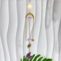 Detail eines goldenen Sonnenfängers mit lila Naturstein und Kristall-Anhängern - Amethyst