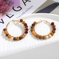 Detail of bohemian gold hoop earrings with handcrafted multicolored natural stone beads - Brown Beads