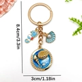 Golden ocean keychain with blue enamel seahorse, shell, and pearl on white background - Blue Enamel Seahorse Shell Style (ER1921)