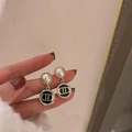 Dettaglio di orecchini a perno dorati con perla bianca e ciondolo floreale in smalto nero - 24# Perno in Argento Nero Logo Perla
