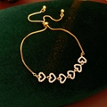 Detail of gold zircon heart bracelet with five sparkling charms on dark green velvet - Gold Full Zirconia Heart