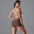 Close-up of brown cross-back sports bra and scrunch butt yoga shorts set on model - Brown