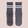 Detail of grey yoga socks with white stripes and black anti-slip grips on the bottom - One Size / Gray