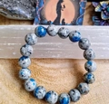 Macro shot of K2 Jasper beaded bracelet on wood with healing crystals and art cards - K2 Stone