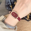 Elegant women's oval wristwatch with burgundy leather strap and gold case on wrist - Ellipse