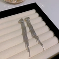 Elegant silver heart earrings with long tassel drapes on a white ceramic display tray - Multi-strand Metal Heart Stud Tassel (HSLA1223 Silver)