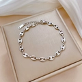 Macro view of silver stainless steel coffee bean link bracelet on soft silk background - Steel