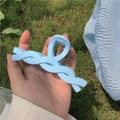 Pinza para el pelo grande en azul claro con diseño trenzado sobre un fondo natural - Azul