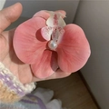 Pink orchid flower hair clip with a centered white pearl shown in a hand-held closeup - Carmine Pink