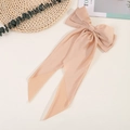 Detail of elegant champagne satin bow hair clip with long ribbons on a creamy background - Khaki