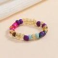 Dettaglio di anello elastico con perline colorate miste su fondo beige in stile boho-chic - Colore Boho Misto