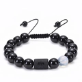 Detailed shot of adjustable Aquarius zodiac bracelet with black agate beads and engraving - Aquarius