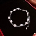 Detail shot of a double-layer pearl bracelet with rhinestone balls on a black velvet box - Silver Round