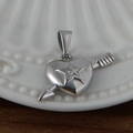 Pendentif coeur en acier argenté avec flèche et étoile sur assiette blanche - Cœur fléché / Acier
