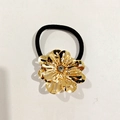 Détail d'un élastique cheveux avec fleur dorée ajourée et strass scintillant - Fleur Creuse Strass