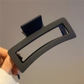 Detail view of a matte black rectangular hollow hair claw clip with sturdy resin spring - 13cm / Black