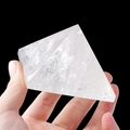 Hand holding a clear natural white crystal pyramid with unique internal ice cracks - 7cm